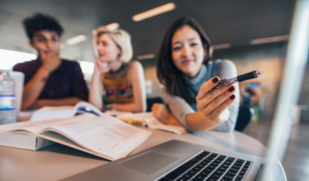 Students in a Library using a MacBook Air for researh